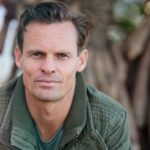 Close-up portrait of a man wearing a casual jacket outdoors.